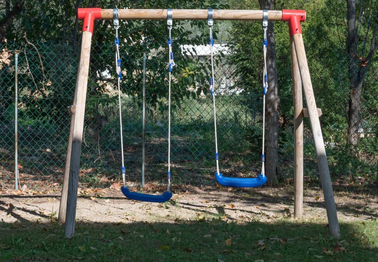 Villa 06PRAD's green lawn with two children's swings for delightful moments